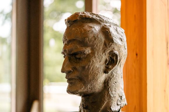 A light brown coloured statue of Yehudi Menuhins Head side on.